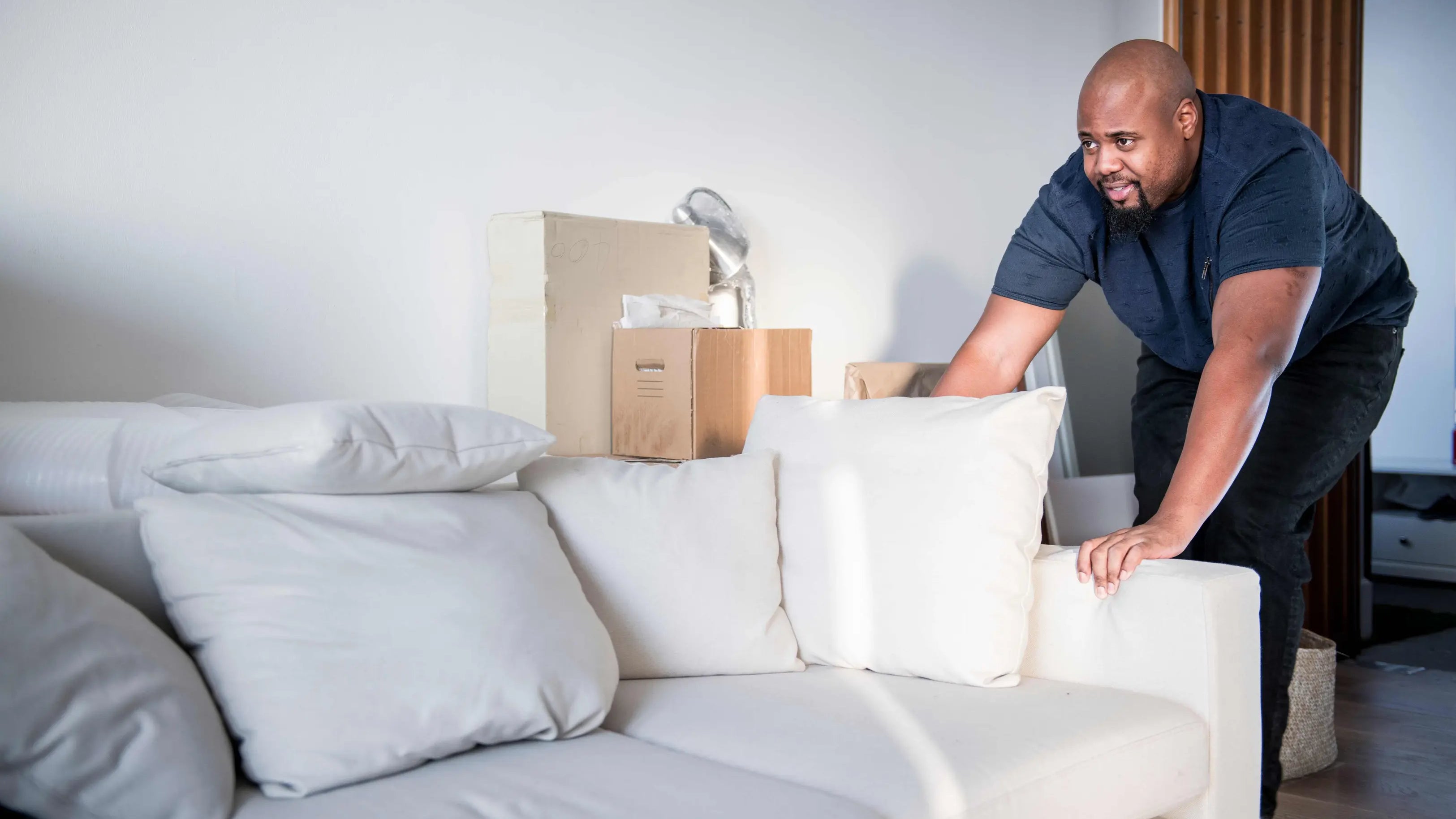 A man slide his couch he want to know how to keep couch from Sliding